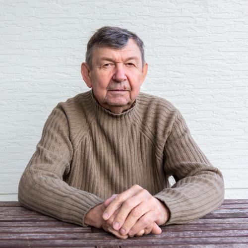 portrait-of-elderly-man-sitting-at-table-2023-11-27-05-23-17-utc